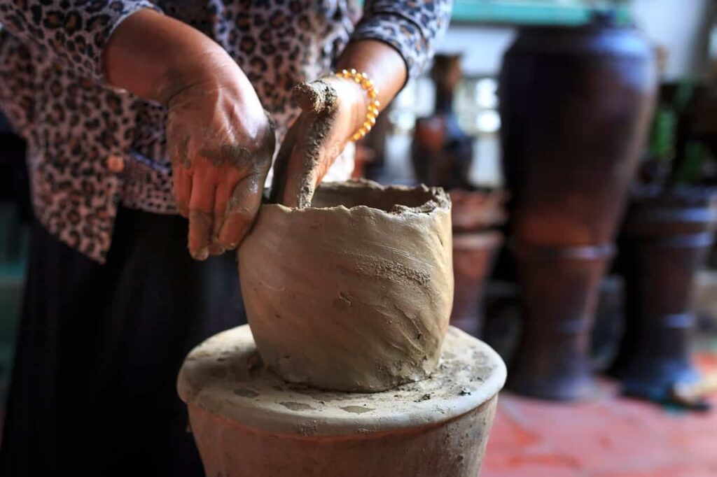 woman shaping a clay pot